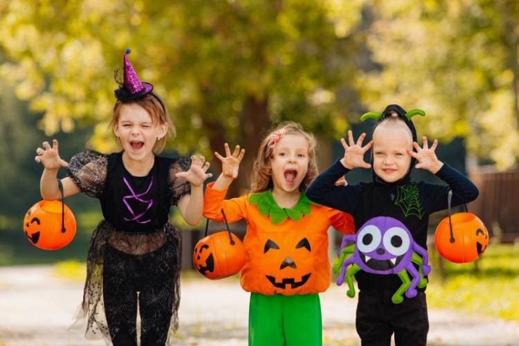 A trio of children dressed up and being scary for their Disneyland Halloween experience.